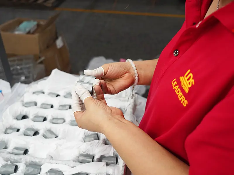 LEADERS factory worker conducting strict quality inspection for Zamac perfume caps