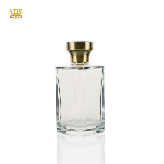 Luxury golden Zamac perfume cap on a clear square glass bottle