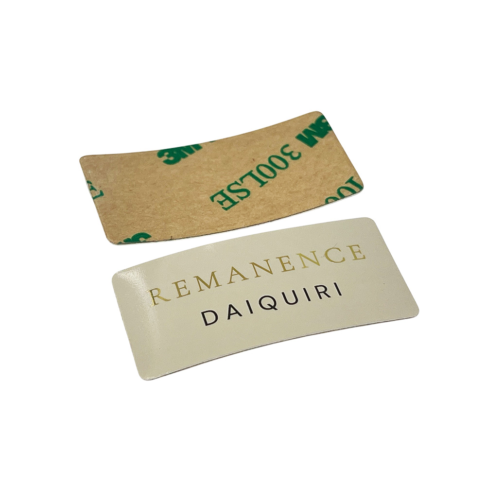 Front and back view of custom curved aluminum perfume label showing 3M 300LSE adhesive tape backing